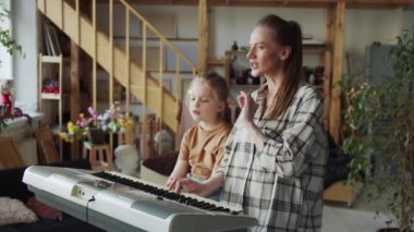 Çocuk bir şarkı öğretmeniyle nişanlı. Bir kadın notalardan şarkı söyler ve sentezleyiciyi çalar. Yüksek kalite 4k görüntü