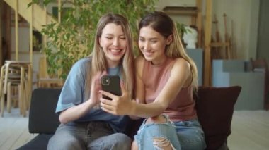 İki genç bayan videoda arkadaşlarıyla konuşuyor, dikkatle dinliyorlar ve gülümsüyorlar. Yüksek kaliteli FullHD görüntüler