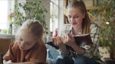 Psikiyatrist küçük hastasının çizimlerini inceliyor. Kadın gördükleriyle nottaki girdileri karşılaştırıyor. Yüksek kalite 4k görüntü