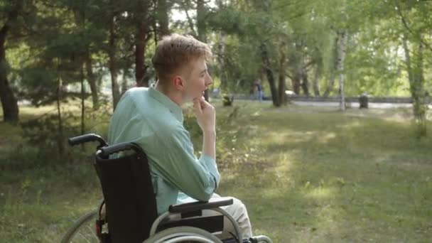 Молодой Инвалид Синей Рубашке Сидит Инвалидном Кресле Слишком Много Думает — стоковое видео