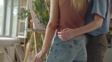 İki genç kız arkadaş stüdyoda dikilip resim çiziyorlar, yakın çekim. Yüksek kaliteli FullHD görüntüler