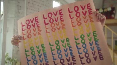 İki yakışıklı genç kız stüdyoda duruyor ve kameraya bir lgbt posteri gösteriyorlar. Yüksek kaliteli FullHD görüntüler