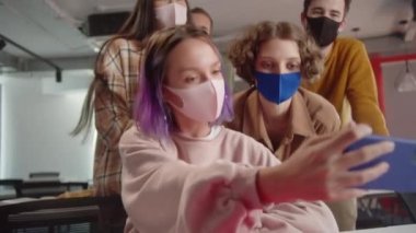 Beş genç sınıf arkadaşı birlikte komik fotoğraflar çekiyorlar, seyirciler arasında oturuyorlar. Yüksek kalite 4k görüntü