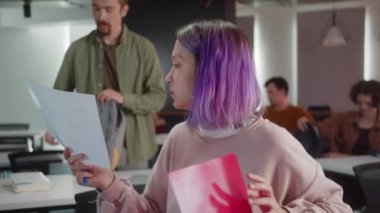 Enerjik genç öğrenciler seminere hazırlanıyor, ödevler hakkında tartışıyorlar ve öğretmeni bekliyorlar, yavaş çekimde yakın çekimde. Yüksek kalite 4k görüntü