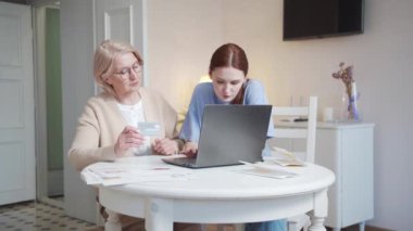 Bir kız ve bir büyükanne bilgisayarın önünde bir masada oturuyorlar. Yaşlı bir kadın satın almaları nasıl ödeyeceğini bir kartla çözmeye çalışıyor ve torunu ona açıklıyor. Yüksek kalite