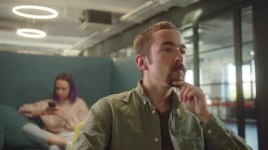 Genç ve yakışıklı bir öğrenci tatilde üniversitenin dinlenme yerinde hayal kuruyor. Yüksek kalite 4k görüntü