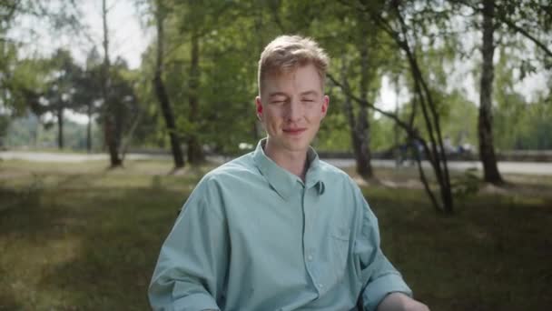 Молодой Белый Инвалид Инвалидной Коляске Сидит Парке Смотрит Камеру Улыбаясь — стоковое видео