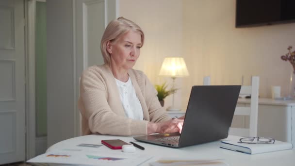 Starší Žena Potíže Používáním Notebooku Pečlivě Označí Text Počítači Prstem — Stock video