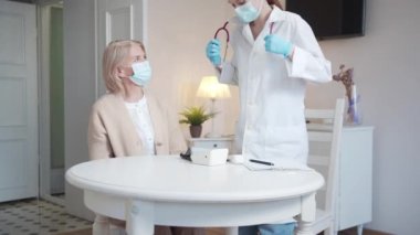 The nurse asks the old woman to take off her cardigan so that the doctor can use the stethoscope. High quality 4k footage