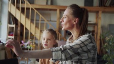 A cheerful and good-natured singing teacher teaches a girl to sing. They memorize notes and use a synthesizer. High quality 4k footage