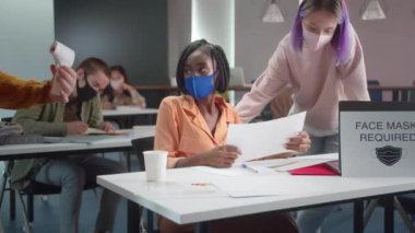 Ders sırasında, genç asistan öğrencilerin sıcaklığını ölçüyor. Yüksek kalite 4k görüntü