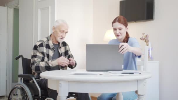 Uma Neta Adulta Mostra Homem Uma Cadeira Rodas Como Usar — Vídeo de Stock