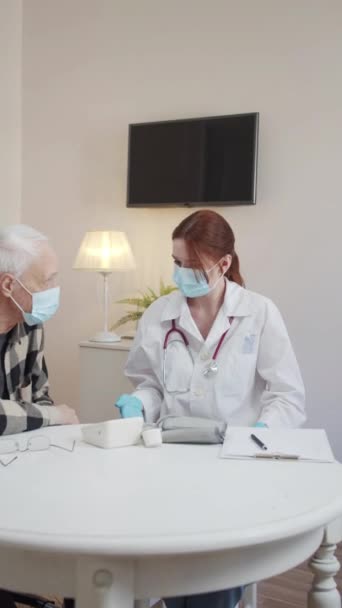 Doctor Medical Mask Gown Communicates Elderly Patient Wheelchair Gives Him — 图库视频影像