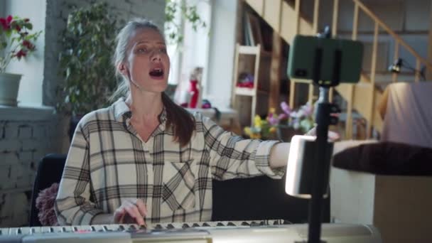 Woman Strikes Difficult Note Singing Lesson She Helps Herself Playing — Vídeo de Stock