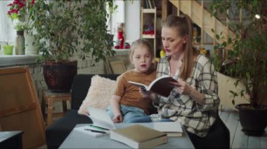 Mom reads a test from a book to a child. The girl looks distracted and uninterested. High quality 4k footage