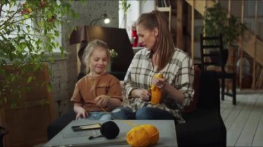 Bir kız ve annesi geniş bir dairede bir sedirin üzerinde oturuyorlar. Önlerindeki masanın üzerine iplikler, yün ve örgü iğneleri serilmiştir. Birbirlerine sarılıp sohbet ediyorlar. Yüksek kalite 4k