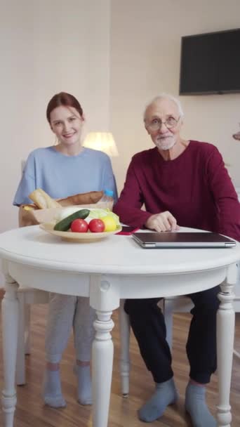 Pensionista Óculos Uma Camisola Borgonha Senta Com Sua Neta Mesa — Vídeo de Stock