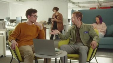 Üniversitede dinlenme alanında oturan iki genç öğrenci, takım çalışmaları ve proje hakkında tartışıyorlar. Yüksek kaliteli FullHD görüntüler