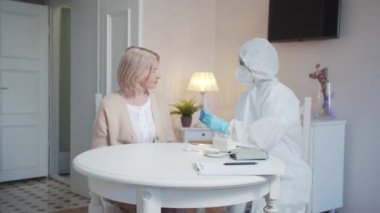 Tulumlu bir doktor emekliler odasına giriyor. Yanına oturuyor ve neden tıbbi maske takman gerektiğini anlatıyor.