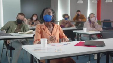 Sınıfta oturan öğretmen öğrencilerinin çalışmalarını dinliyor. Yüksek kalite 4k görüntü