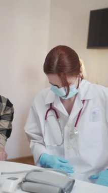 Hijyenik çağrı. Sabahlık giymiş bir kadın, tekerlekli sandalyedeki bir emeklinin odasına giriyor. Ona tıbbi bir maske veriyor ve nasıl takacağını söylüyor. Yüksek kaliteli FullHD görüntüler