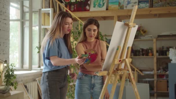 Two Lovely Girlfriends Standing Studio Smiling Drawing Picture Together High — Stock Video