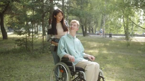 Μια Όμορφη Ασιάτισσα Μακριά Σκούρα Μαλλιά Αγκαλιάζει Τον Ανάπηρο Νεαρό — Αρχείο Βίντεο