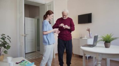 Antrenör dedeye kablosuz kulaklık verir ve bilgisayarı çalıştırır. Bir adam ekrana bakar ve egzersizleri tekrarlar. Yüksek kalite 4k görüntü