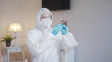 Üniformalı bir doktor yaşlı bir kadının omzunu pamuklu bezle siler ve aşı yapmaya hazırlanır.