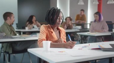 Genç sınıf arkadaşları teneffüste birlikte takılıyorlar ve öğretmen onlara gülüyor. Yüksek kalite 4k görüntü