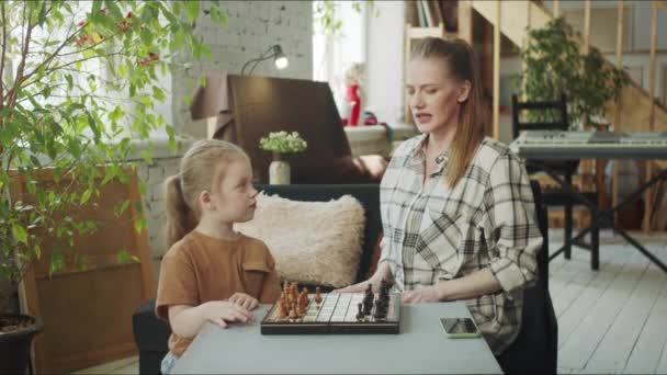 妈妈听女儿讲国际象棋规则 高质量的4K镜头 — 图库视频影像