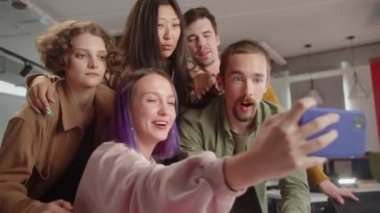 Beş öğrenciden oluşan bir grup, üniversitedeki konferans salonunda birlikte komik fotoğraflar çekiyorlar. Yüksek kalite 4k görüntü