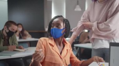 Ders sırasında, genç asistan öğrencilerin sıcaklığını ölçüyor. Yüksek kalite 4k görüntü