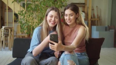 İki tatlı Igbt hanımı video görüşmesinde arkadaşlarıyla konuşuyor, dinliyorlar ve gülümsüyorlar. Yüksek kaliteli FullHD görüntüler