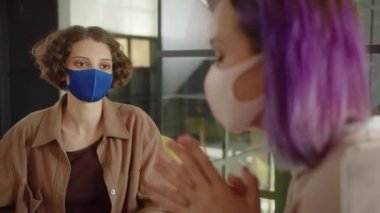 Kısa mor saçlı genç bir kız öğrenci izlenimlerini arkadaşlarıyla paylaşıyor, mola yerinde dinlenme yerinde oturuyor, yakın çekim. Yüksek kalite 4k görüntü