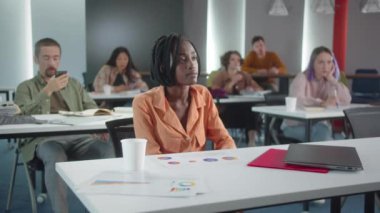 Öğrenciler sınıfta oturuyor ve öğretmen öğrencilerin cevaplarını dinliyor. Yüksek kalite 4k görüntü