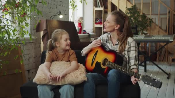 Młody Nauczyciel Śpiewa Wesołą Piosenkę Gitarze Dziewczynka Patrzy Kobietę Uśmiecha — Wideo stockowe