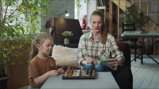 Bir Kadın Çocuğu Internette Satranç Kurallarını Arıyorlar Masanın Yanına Otururlar — Stok video