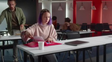 Enerjik genç öğrenciler seminer için hazırlanıyorlar, birlikte konuşuyorlar ve öğretmeni bekliyorlar. Yüksek kalite 4k görüntü