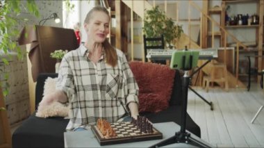 Bir kadın blogcu akıllı telefonundan yayın yapmaya başlıyor. Gösterip satranç taşları hakkında konuşuyor. Yüksek kalite 4k görüntü