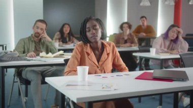 Öğrenciler sınıfta oturuyor ve öğretmen öğrencilerin cevaplarını dinliyor. Yüksek kalite 4k görüntü