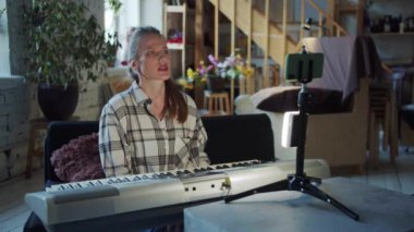 Bir kadın telefonuyla yayına başlıyor ve sentezleyiciyi çalmaktan bahsediyor.