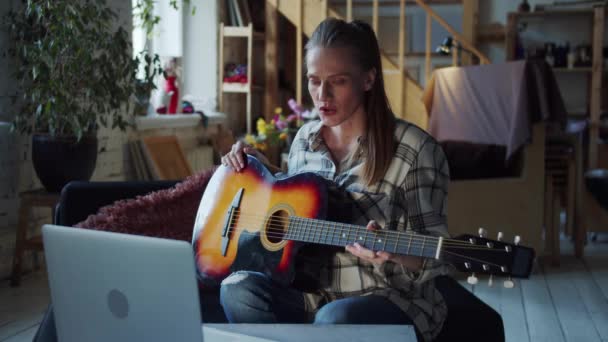 Μια ενήλικη γυναίκα μαθαίνει να παίζει κιθάρα μαζί με έναν απομακρυσμένο δάσκαλο. — Αρχείο Βίντεο