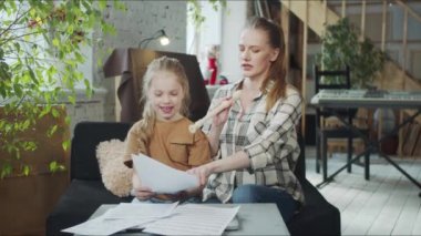 Anne ve kızı flüt çalmayı öğreniyor ve şarkı söylüyorlar.