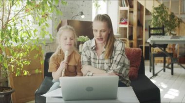  Çocuk annesiyle birlikte müzik öğretmenini selamlar ve flüt çalmayı tartışır.