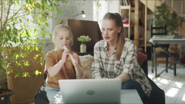 妈妈和女儿一起学习长笛，并在笔记本电脑上使用视频课程 — 图库视频影像