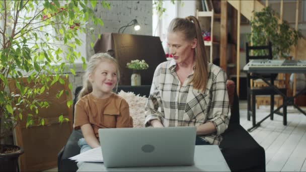Жінка і її дочка спілкуються з родичами за допомогою відеодзвінка — стокове відео