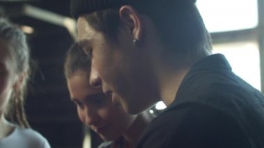 Bir grup okul çocuğu dans sınıfında durup birbirleriyle konuşuyorlar.