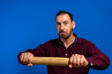 Sakallı, tahtadan bir oklavayla yoğurma hareketini yapan İspanyol asıllı bir adam. Kutlama için bir sürü pasta yapması gerekiyor ve hiç zamanı kalmadı..