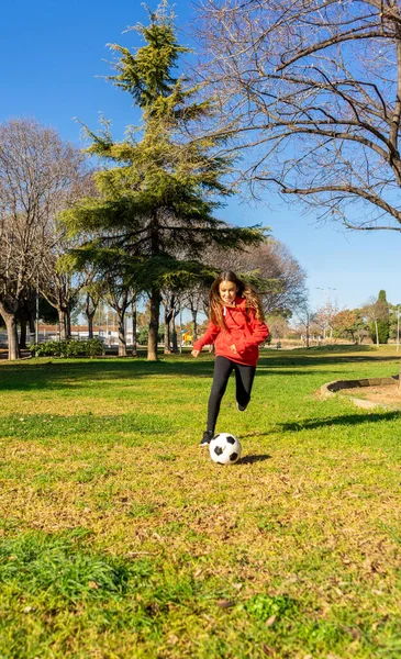 Pre-adolescent meisje voetballen in een park met natuurlijk gras. Oefenconcept — Stockfoto